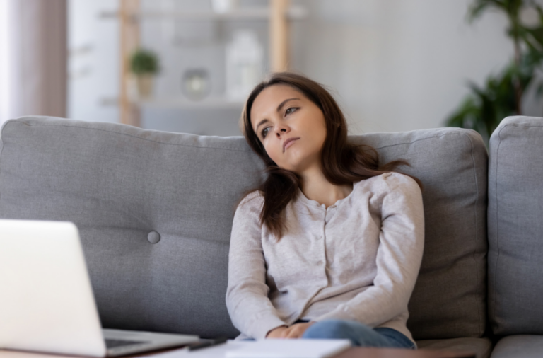 Woman bored on couch with Laptop